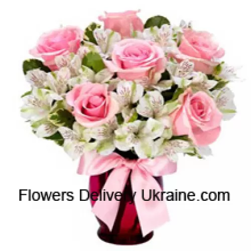 Roses roses et alstroémères blanches arrangées magnifiquement dans un vase en verre
